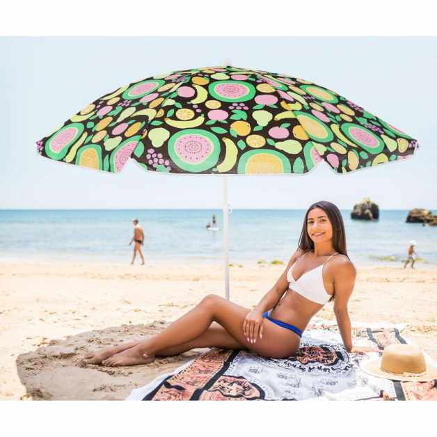 Young latin girl in bikini lying under color umbrella on the beach in sunny hot day.